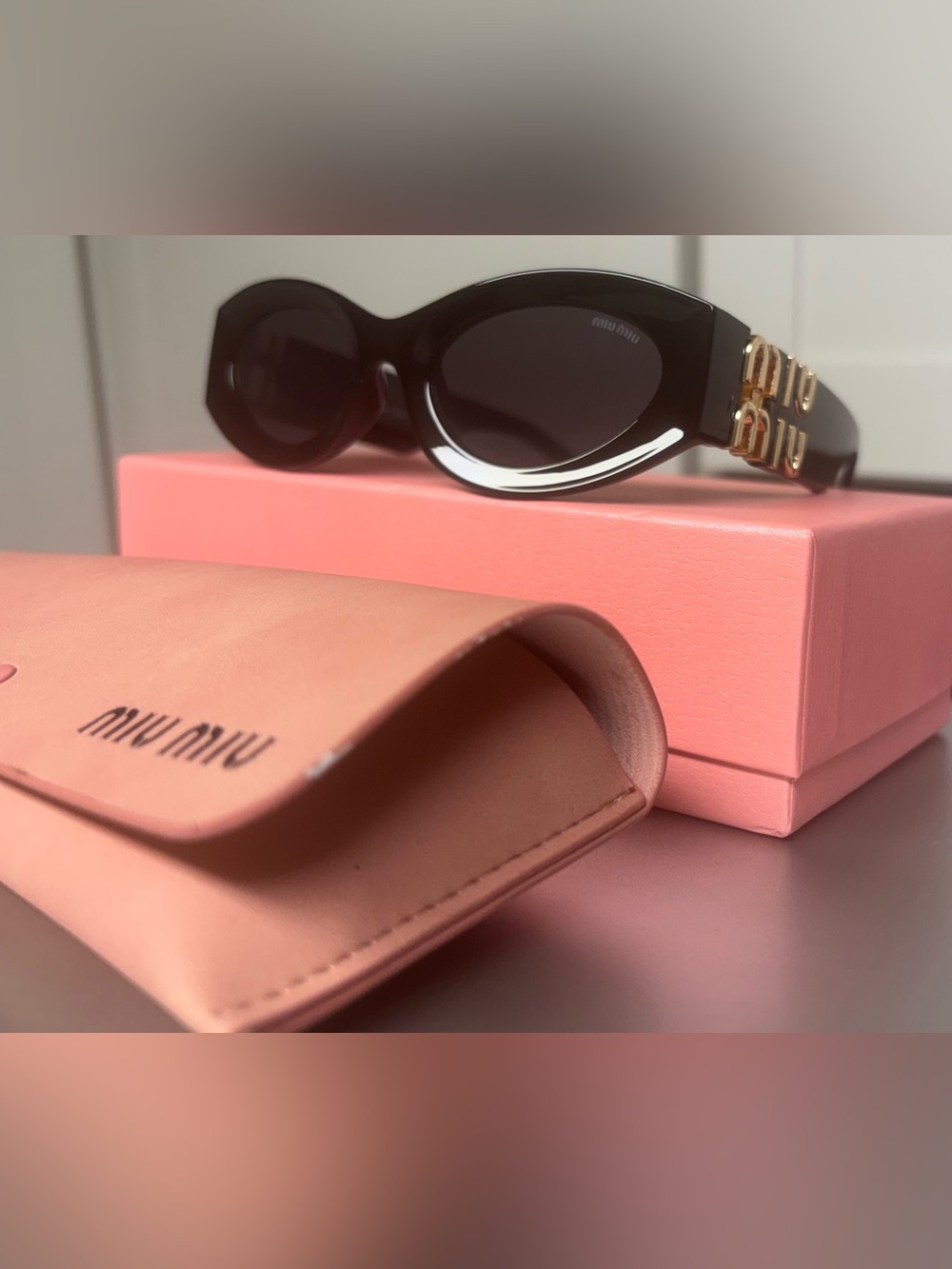Miu Miu Black Oval Sunglasses with Gold Accent